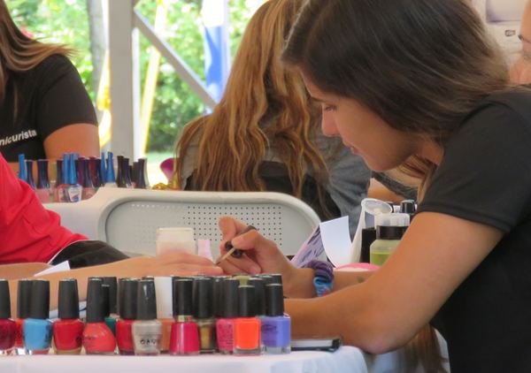 Manicurista pintando uñas en un evento